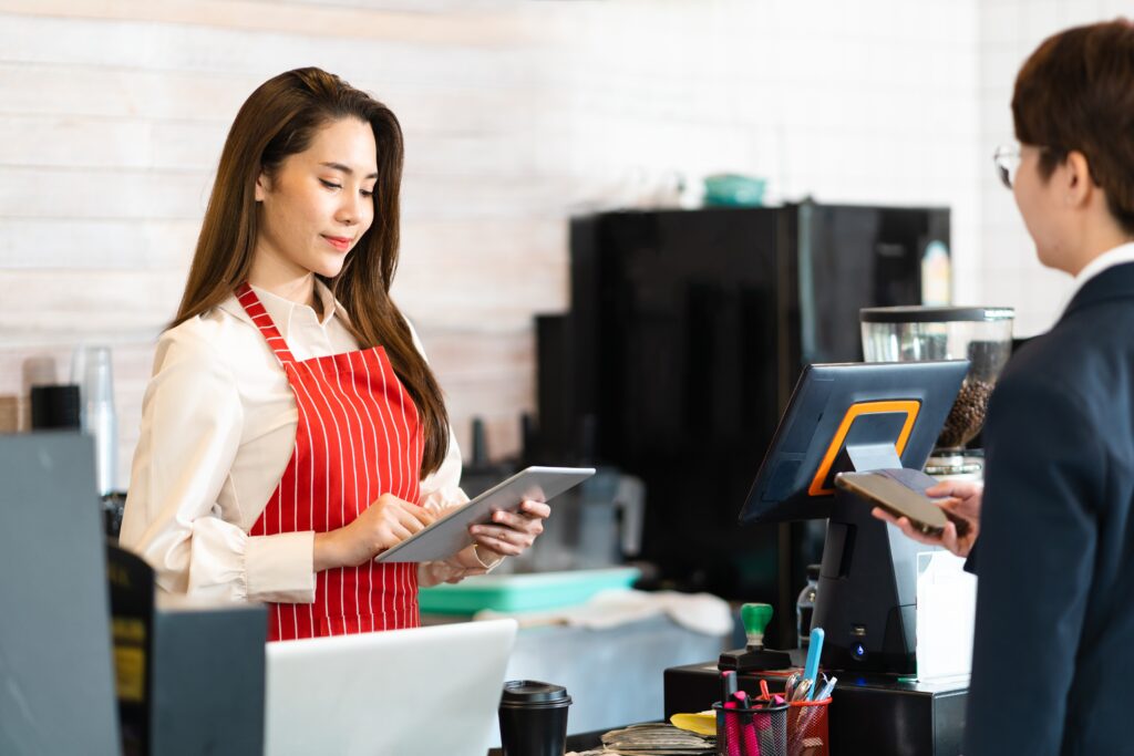 A Malaysian cafe owner using an all-in-one POS system, which is more capable than cash registers.