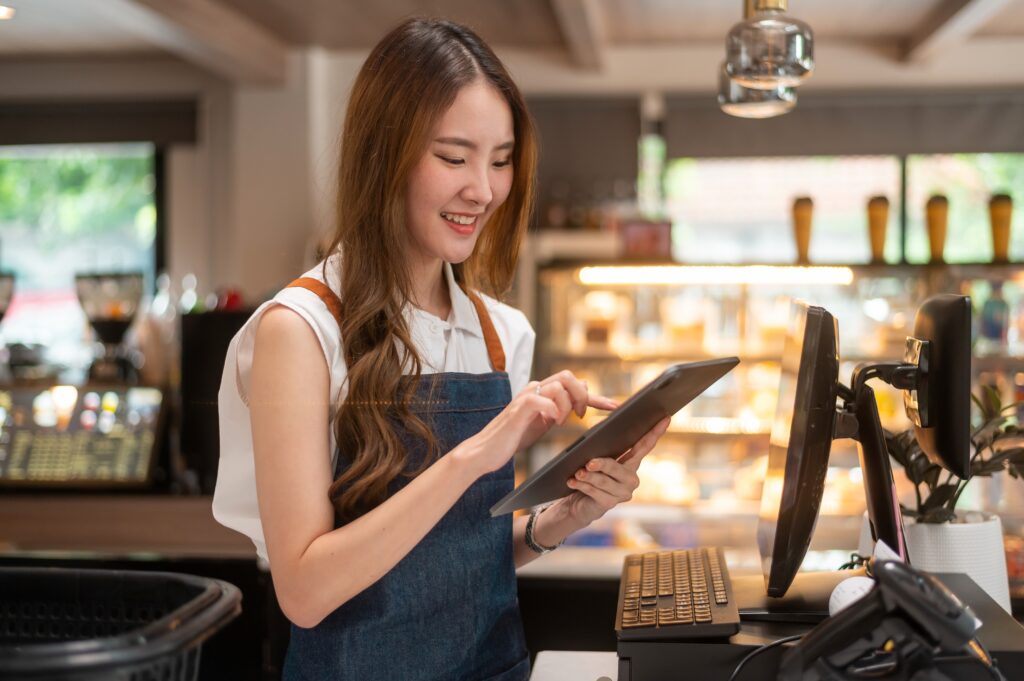 Restaurant owner checking daily sales on a tablet connected to a cloud POS system for restaurants.