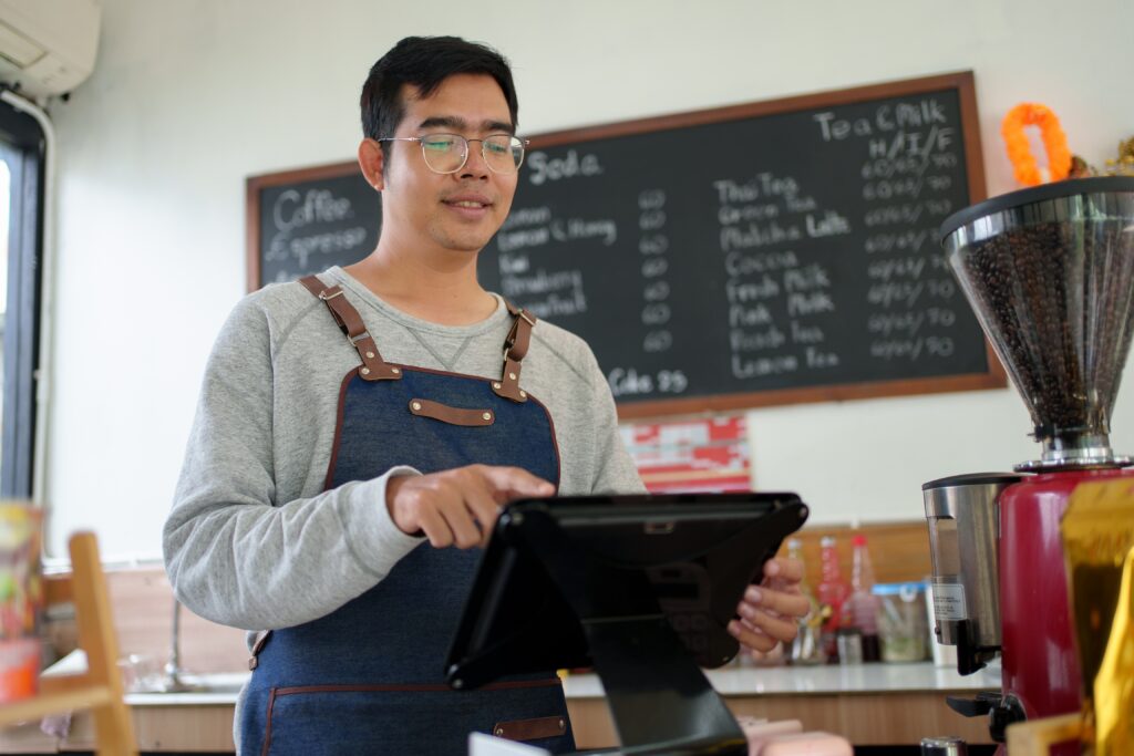 An SME owner making a vetting call to a POS system supplier in Malaysia at a café.